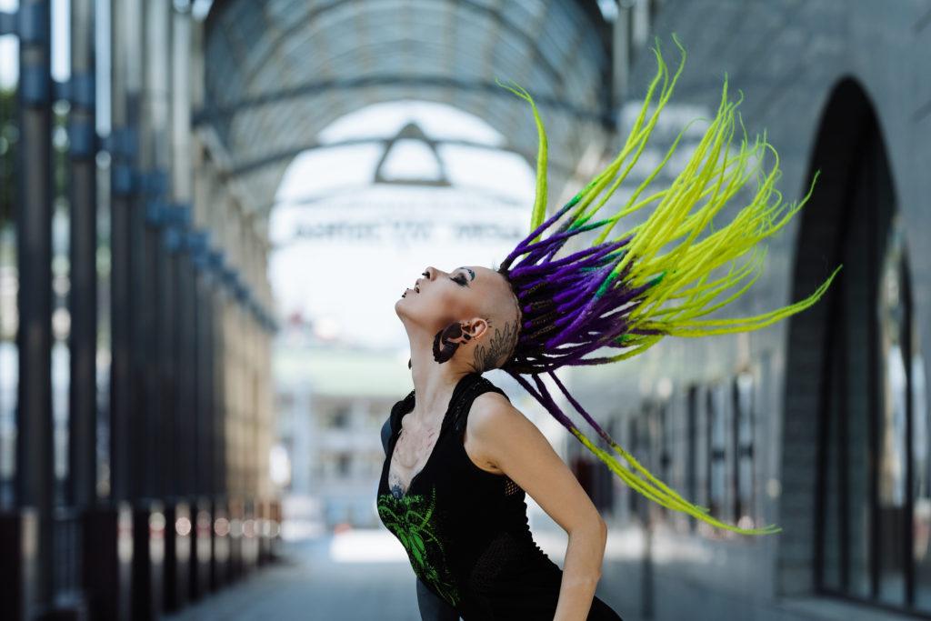 black, purple and lime green dreadlocks on a tattooed girl