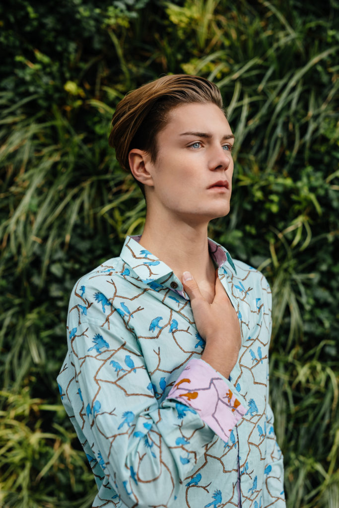 High Fashion boy posing in front of vertical gardens